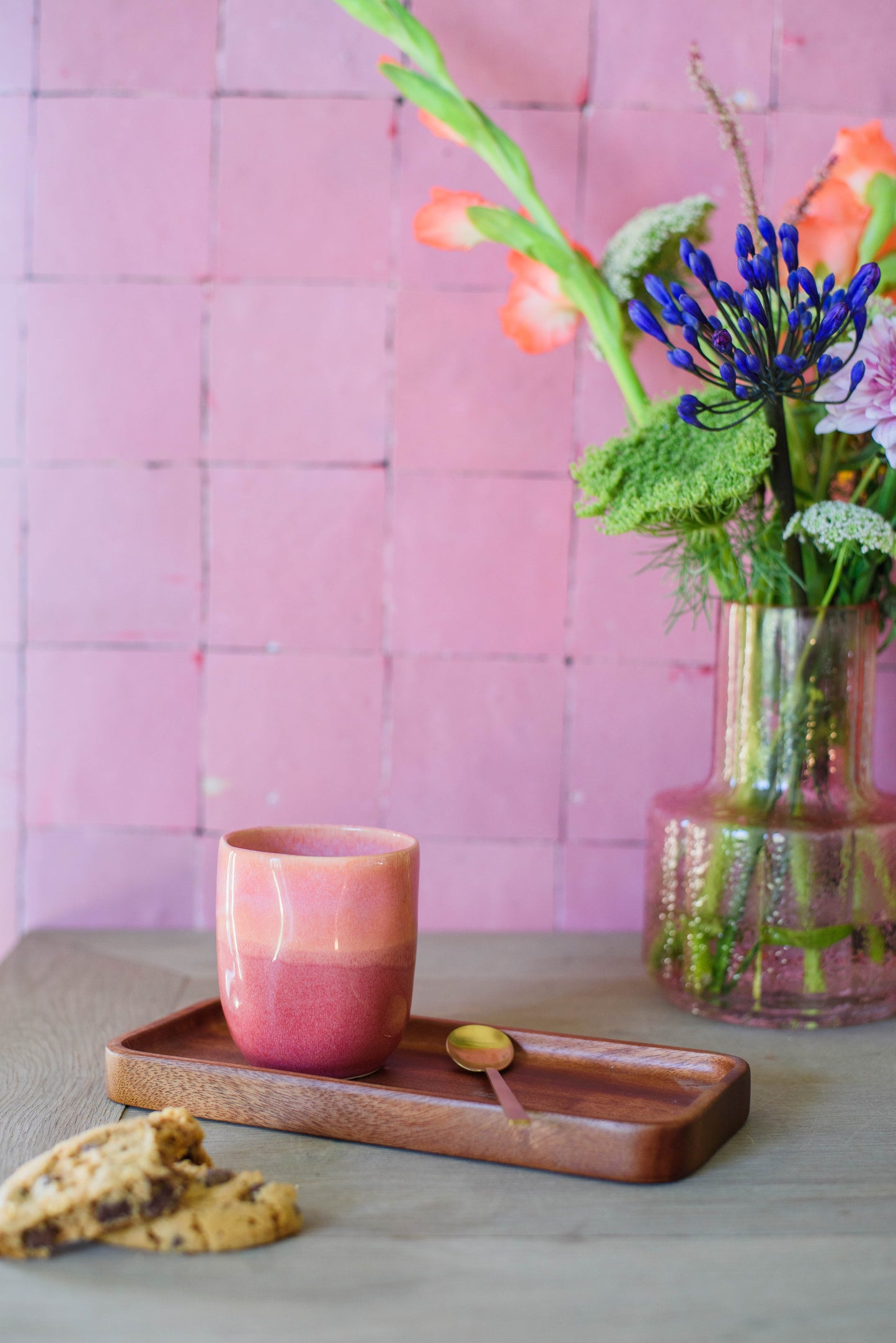 sfeerfoto voor een roze muur met een koffiekopje zonder oor in de kleur roze
