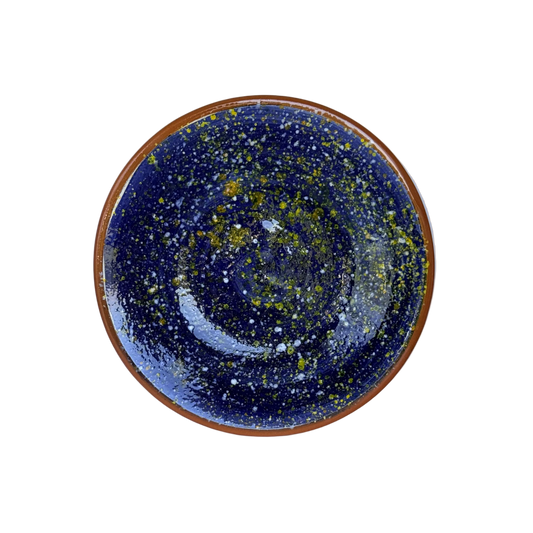 detailfoto bovenkant bordje handgemaakt keramiek uit Portugal donkerblauw met gele en witte spetters
